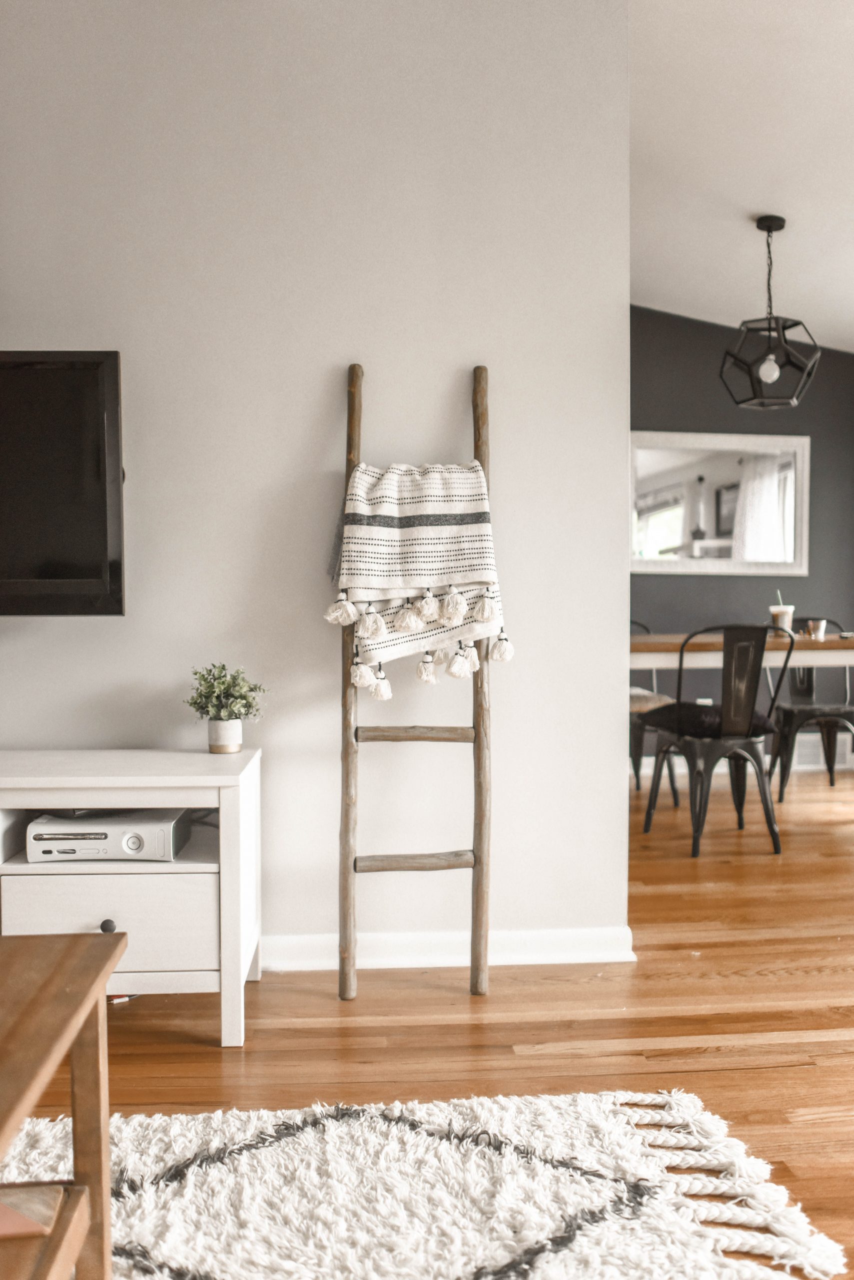 Moderná obývačka v škandinávskom štýle s dreveným rebríkom a dekou
