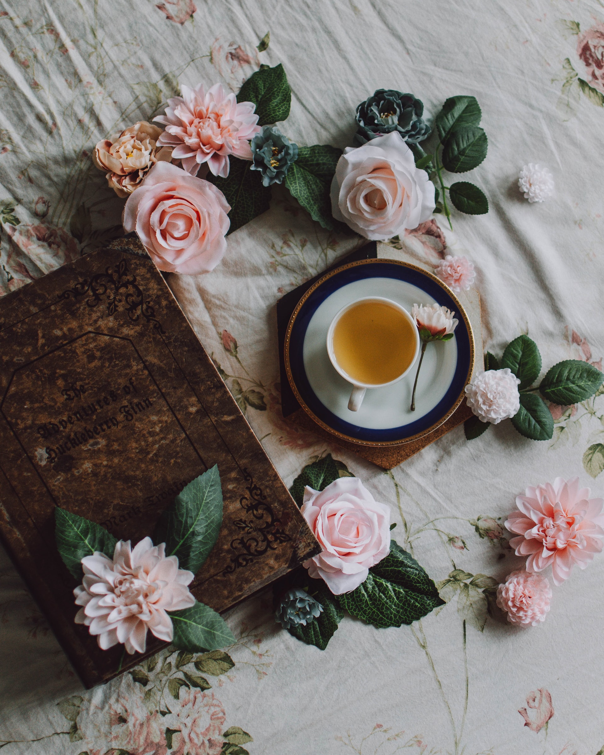 šálka čaju na stole s ružami