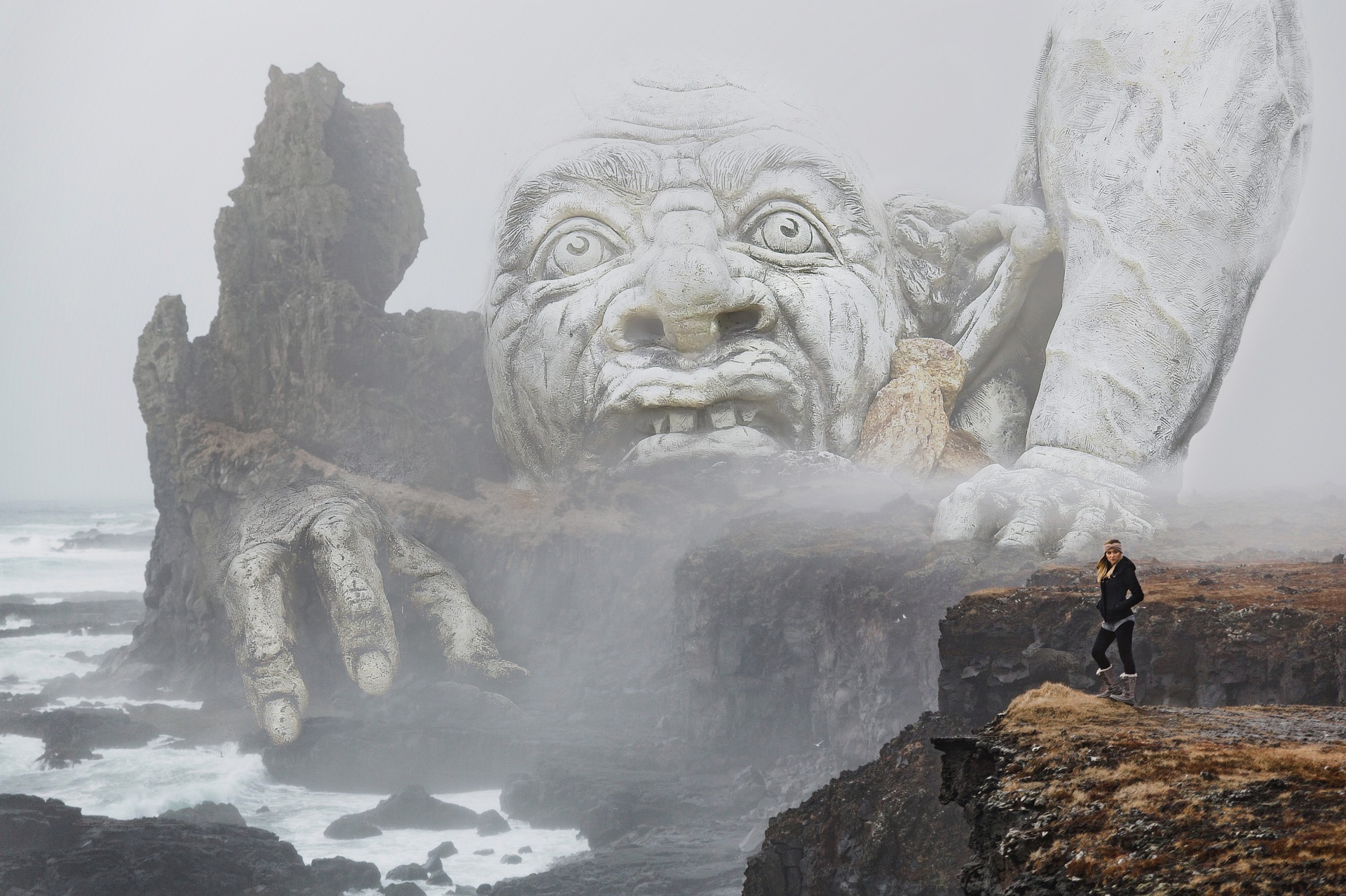 žena stojaca na útese pred obrovským trollom