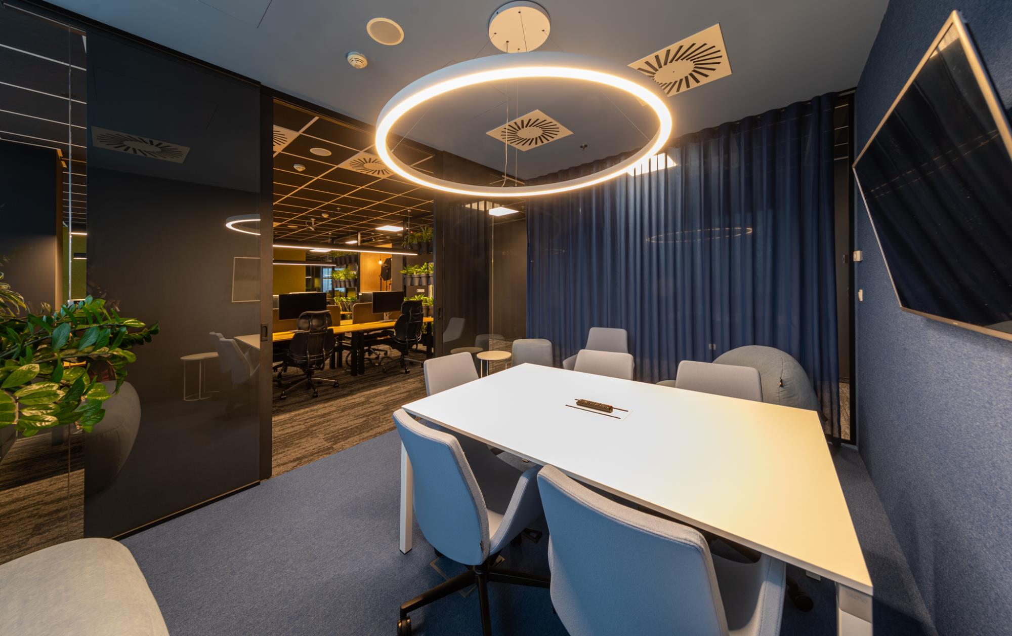 výrazné osvetlenie interiéru vo firme s pohodlnou zasadacou miestnosťou a kanceláriami