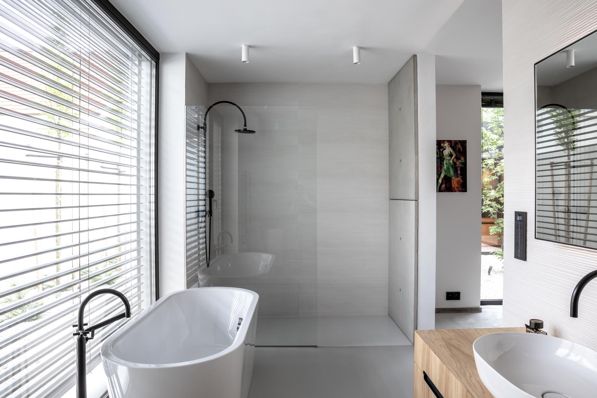 moderná kúpeľňa s výraznými betónovými prvkami a elegantnou vaňou