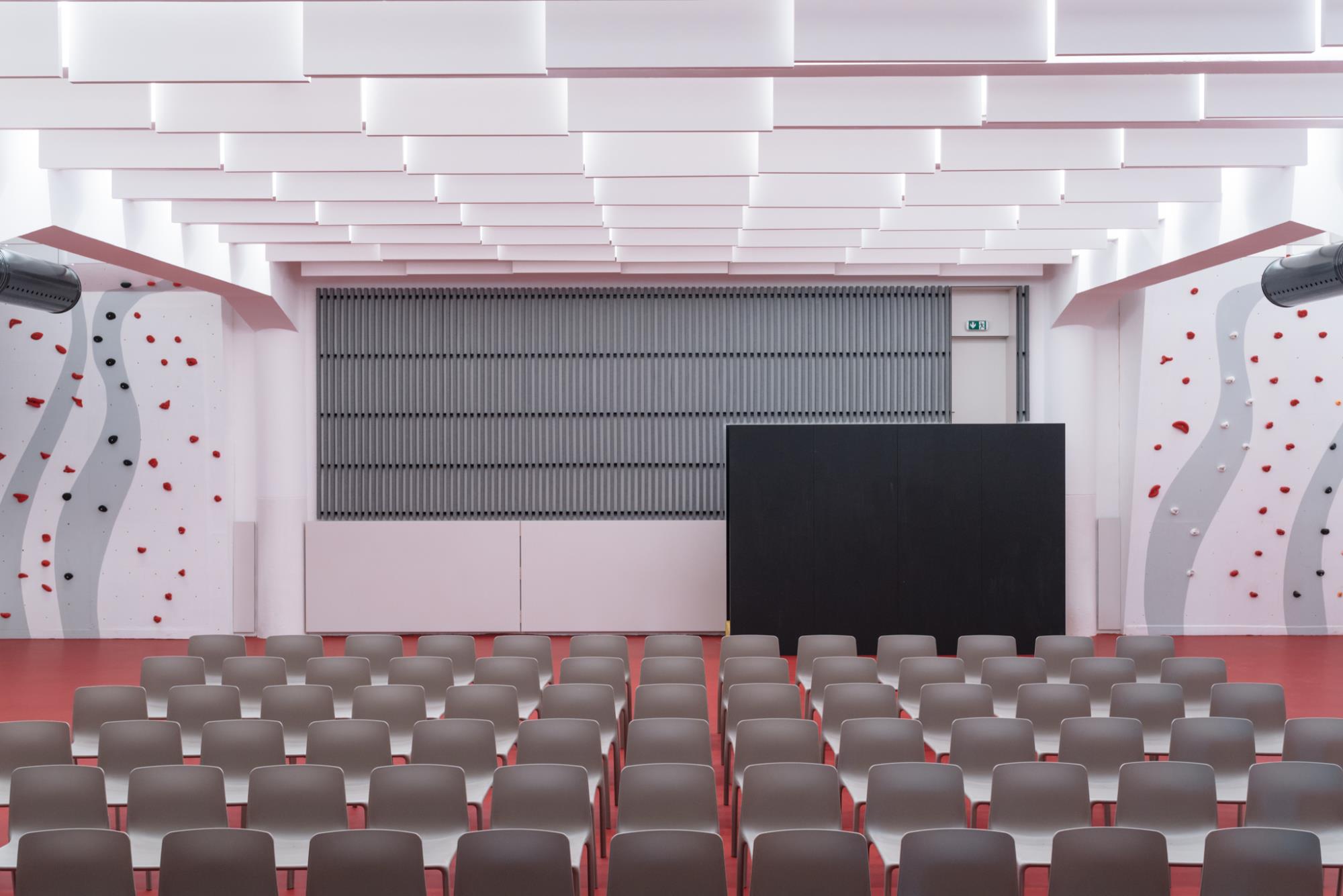 multifunkčný priestor pre návštevníkov divadelnej sály s výraznou červenou podlahou