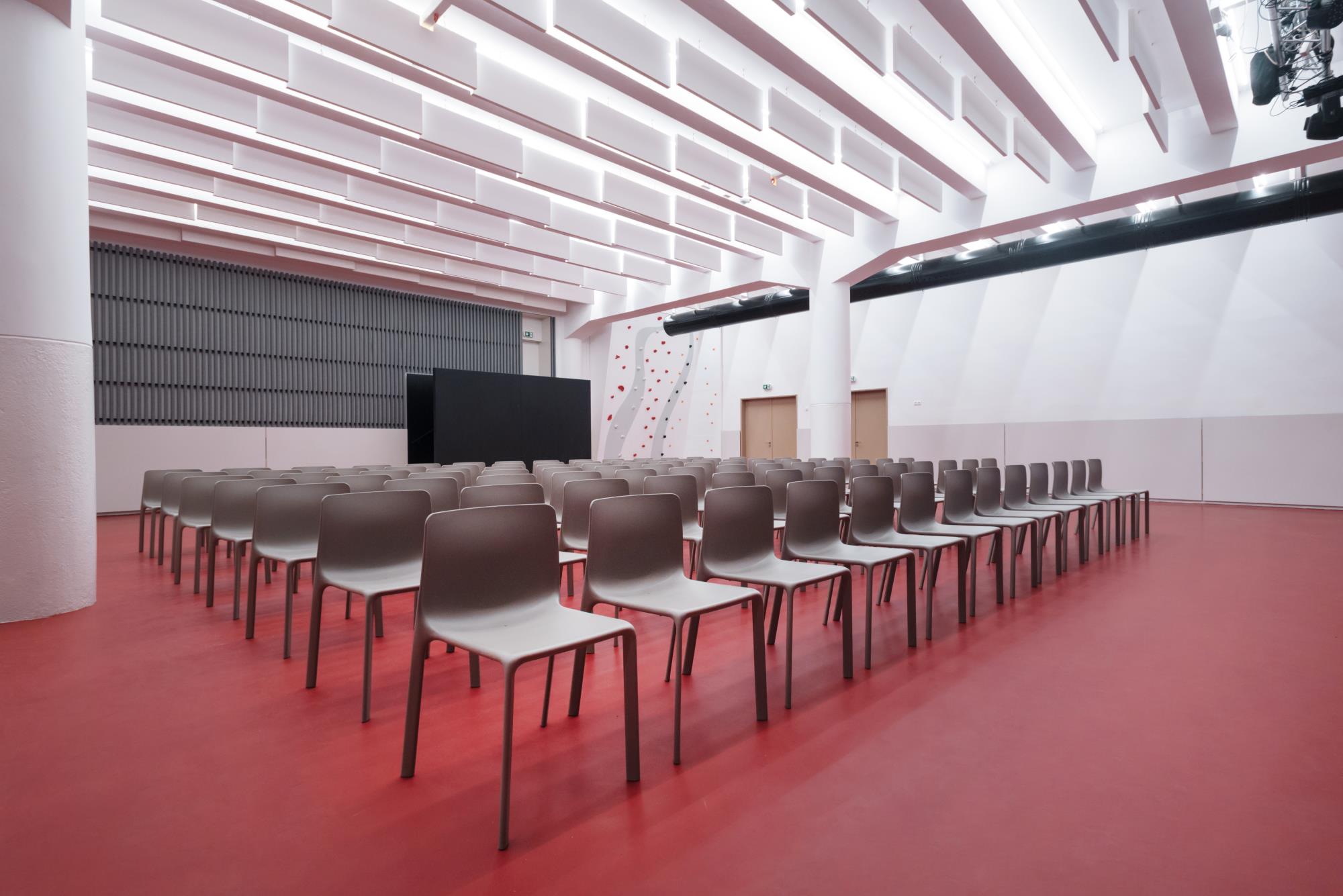 multifunkčný priestor pre návštevníkov divadelnej sály s výraznou červenou podlahou