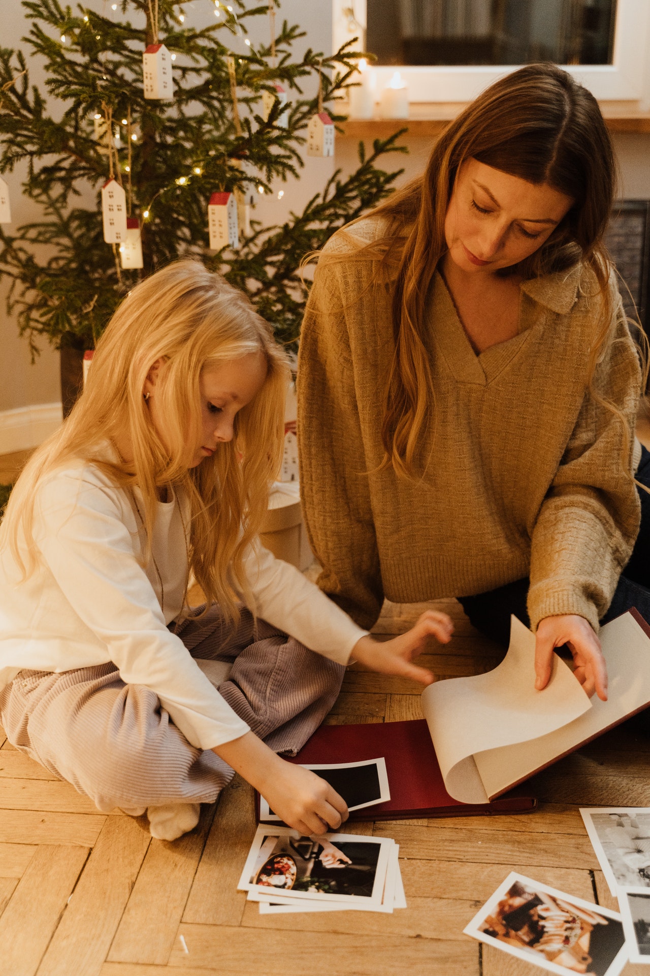 mama s dcérou pri vianočnom stromčeku pozerajú fotografie