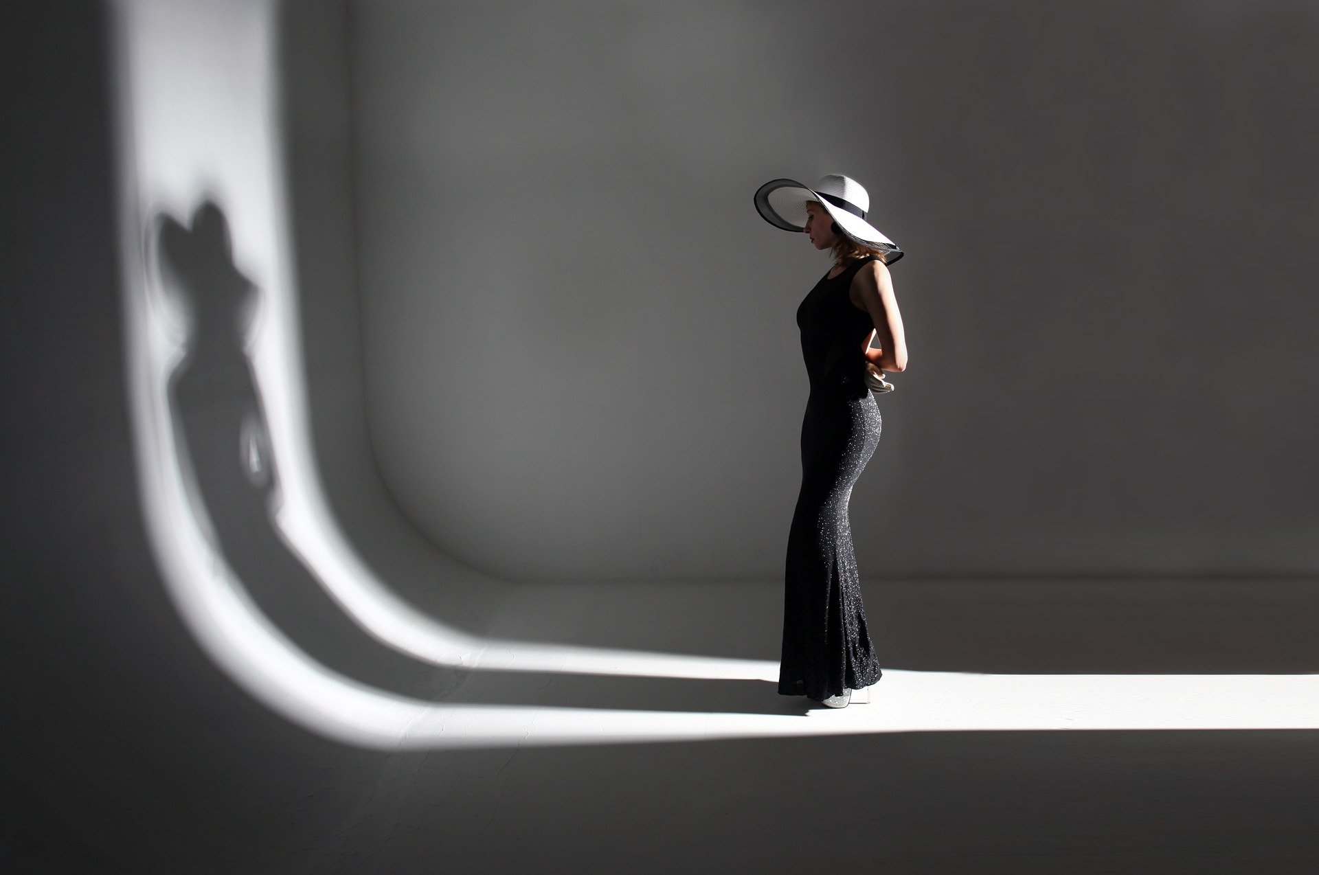 žena v čiernom obdivujúca svoj tieň